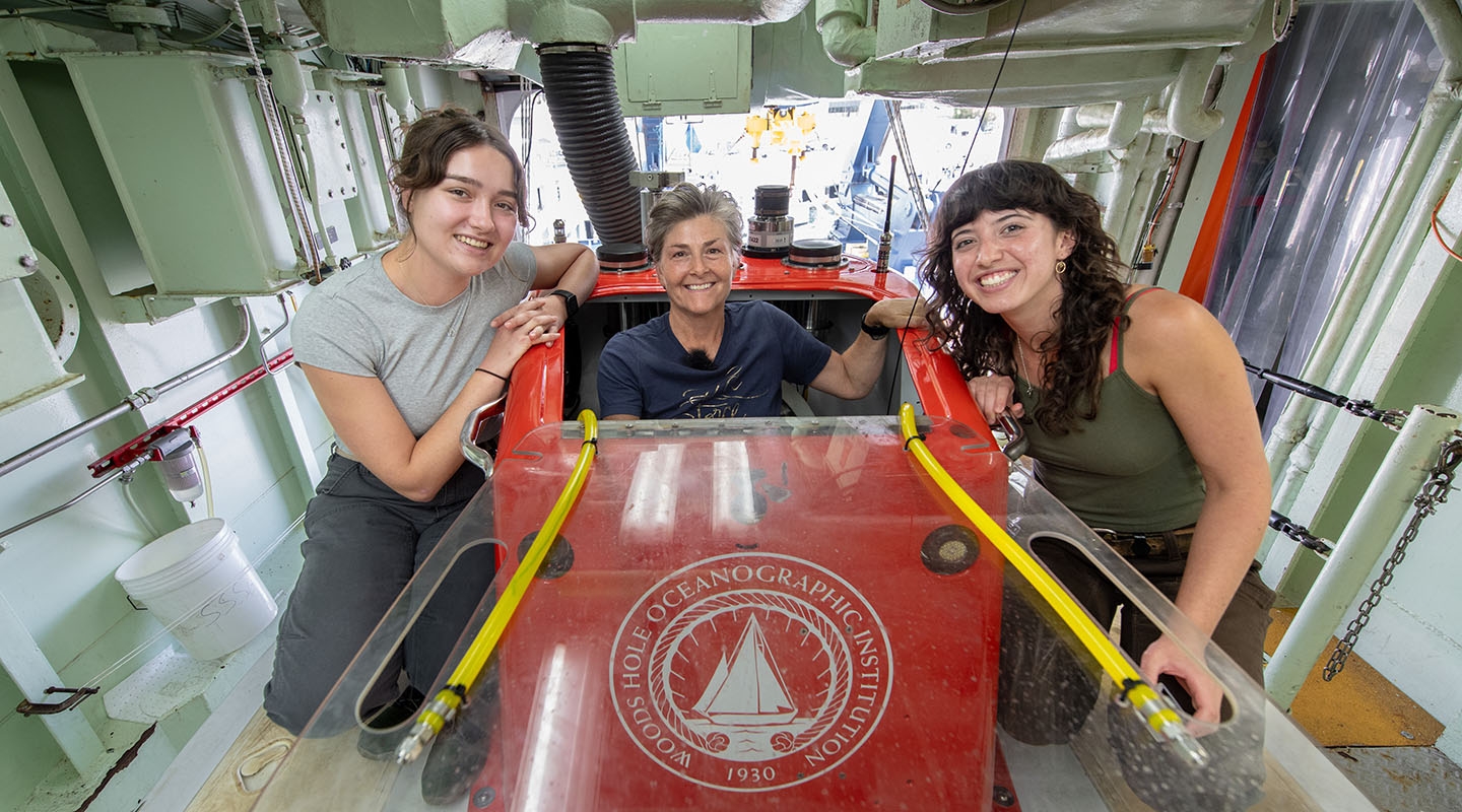 Two Occidental College undergrads and their professor next to a submersible ocean research vessel