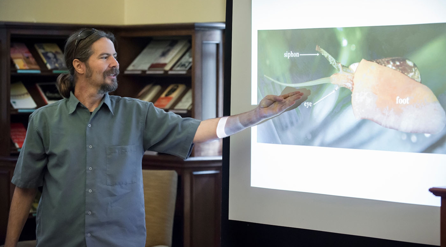 Prof. Joseph Schulz talks about cone snails, referring to a projected slide
