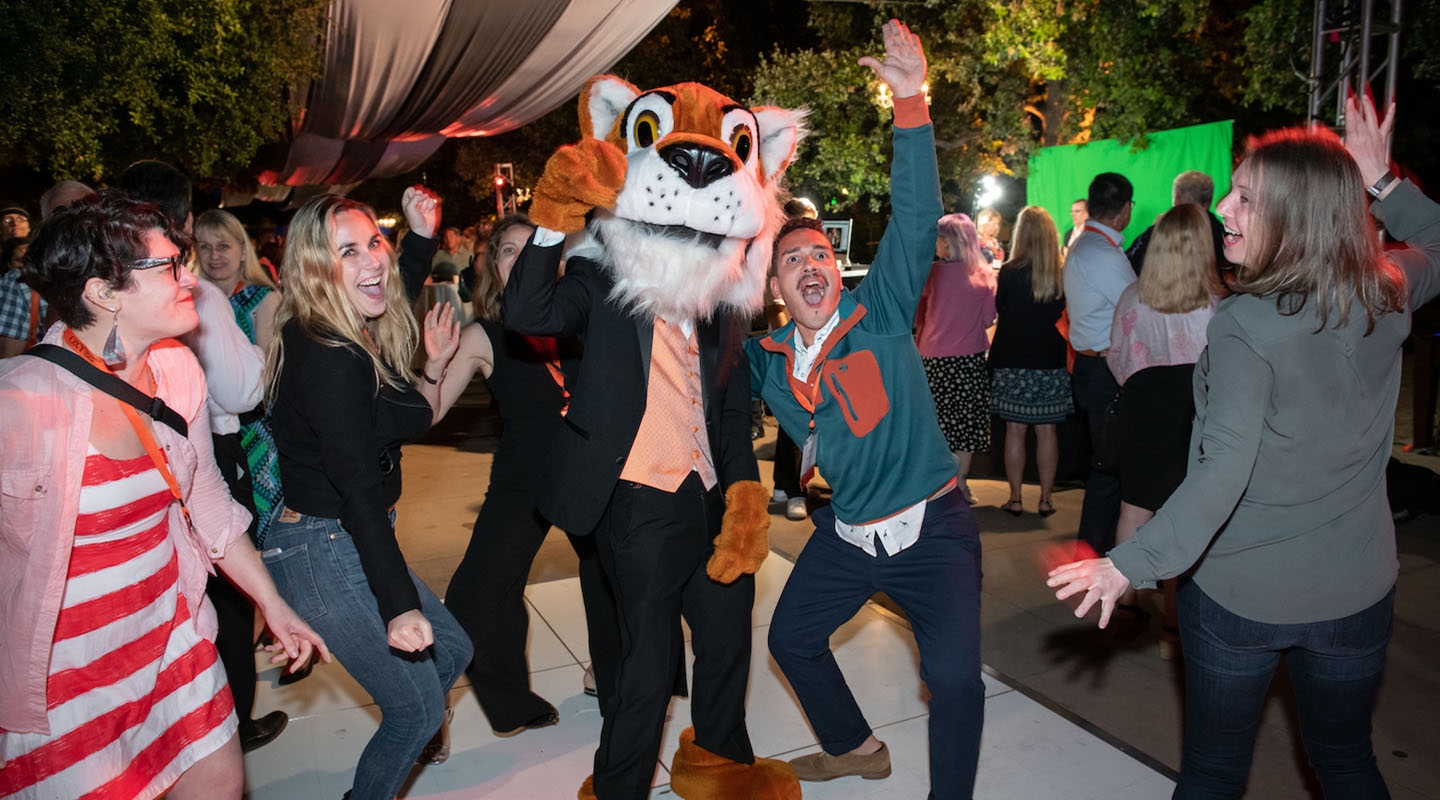 Happy Oxy alumni standing with Oswald at the alumni reunion event on campus.