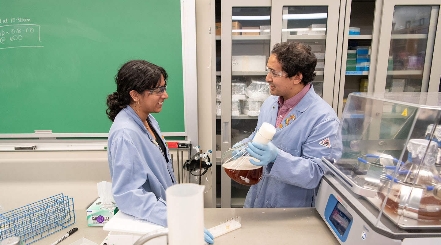 An Oxy professor in the chemistry lab, showing a student some tools