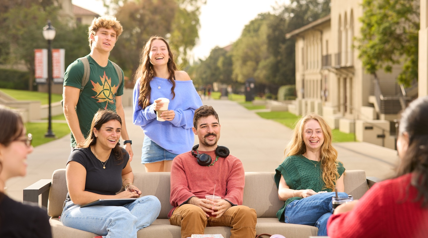 A group of students laughing together on the Occidental College campus