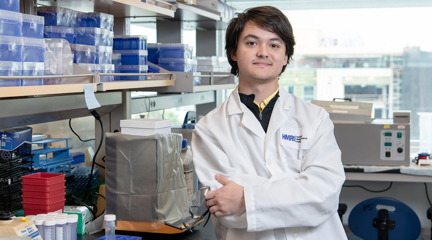 An Occidental College student in a white coat in the science lab