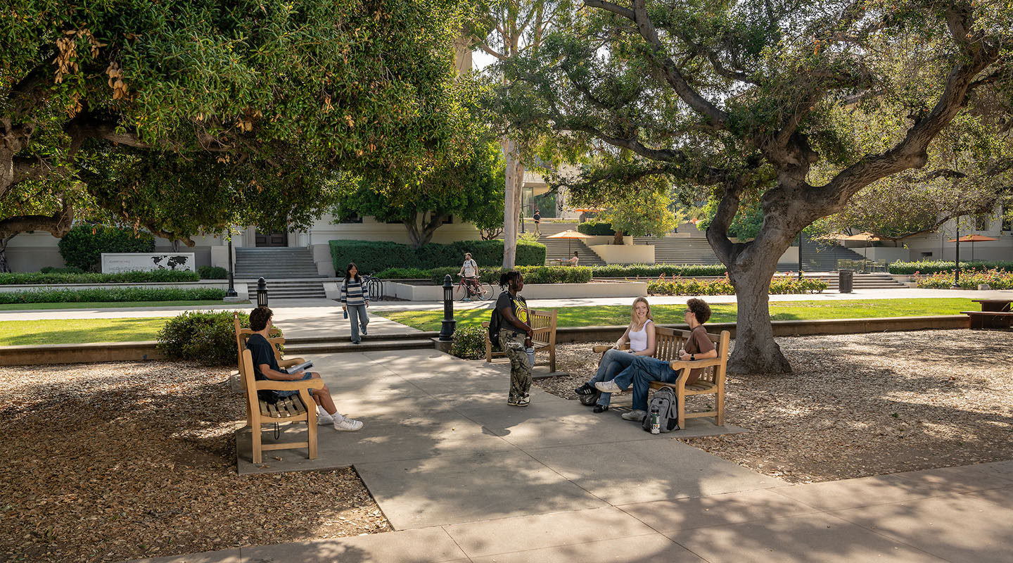 The Occidental College Quad with afternoon sunlight and a few students standing around talking