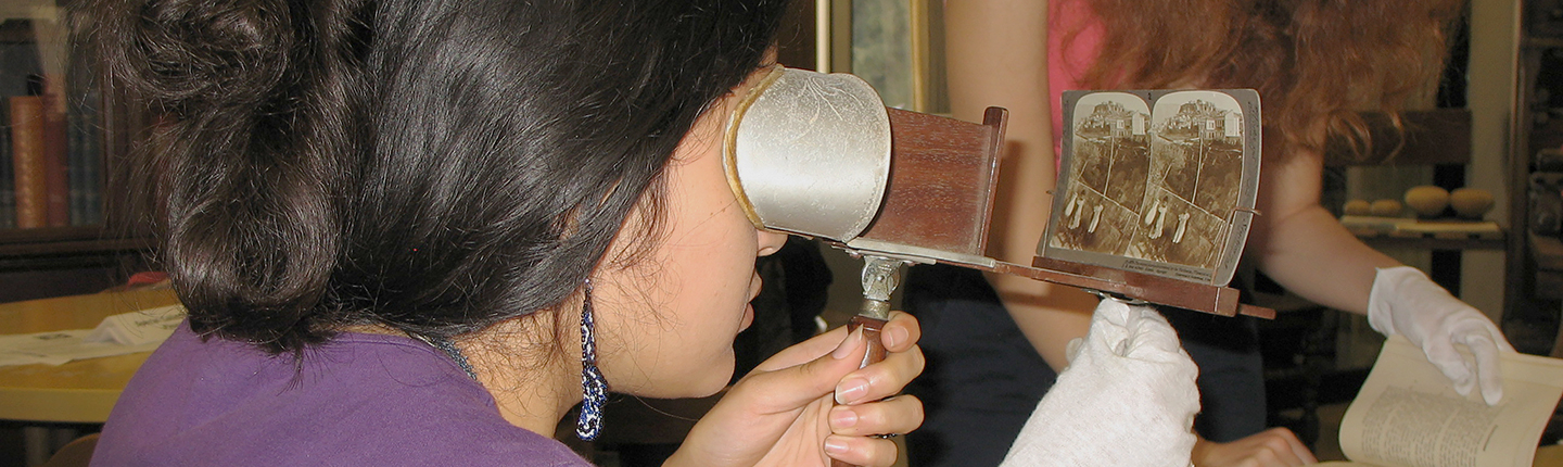 An Occidental (Oxy) student using an antique stereoscope to view a stereograph card