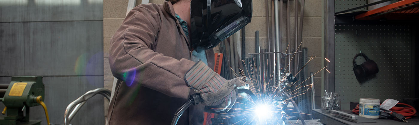 An Occidental (Oxy) student welding in a workshop