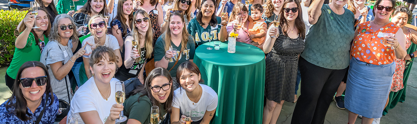Members of Delta Omicron Tau spannng five decades raise a glass at the Delta House one last time on October 19.
