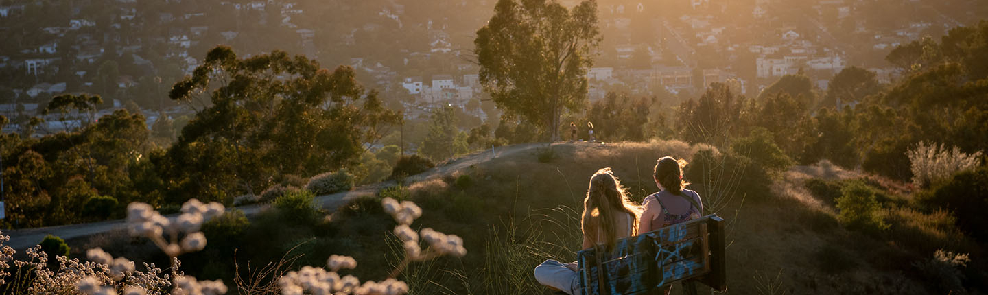 two Occidental students in a late afternoon sun-drenched scene on top of Fiji Hill at sunset