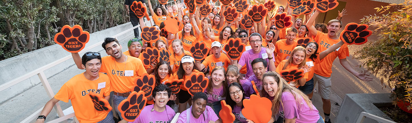 O Team students in a big crowd cheering in orange Oxy tshirts