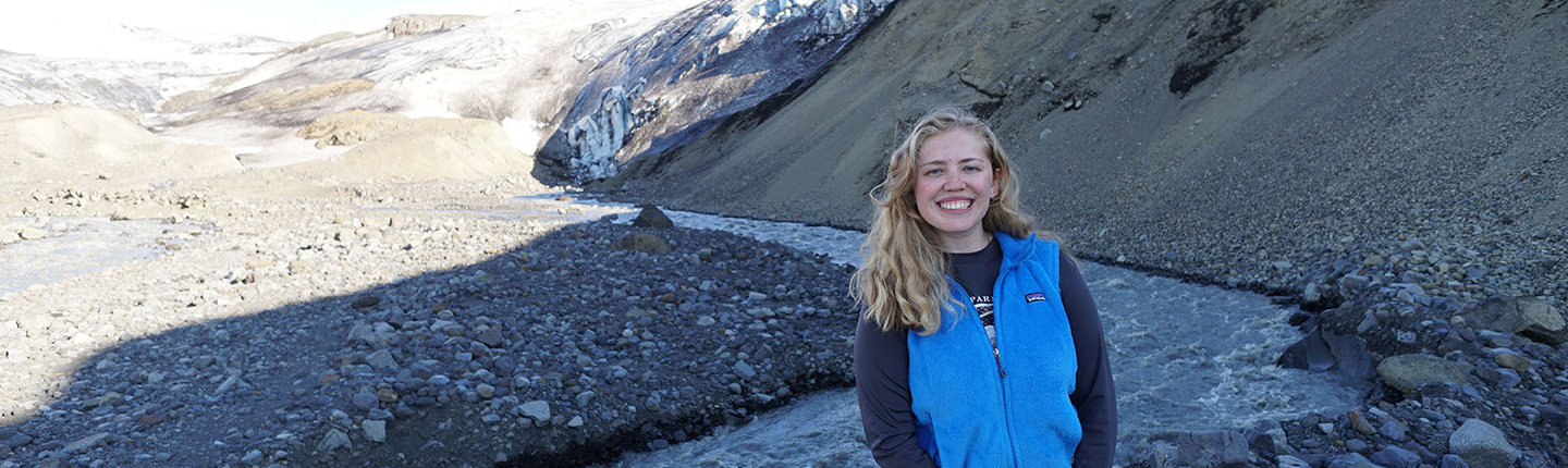 Occidental College alumna Lauren Berger '19 standing next to a glacier in Iceland
