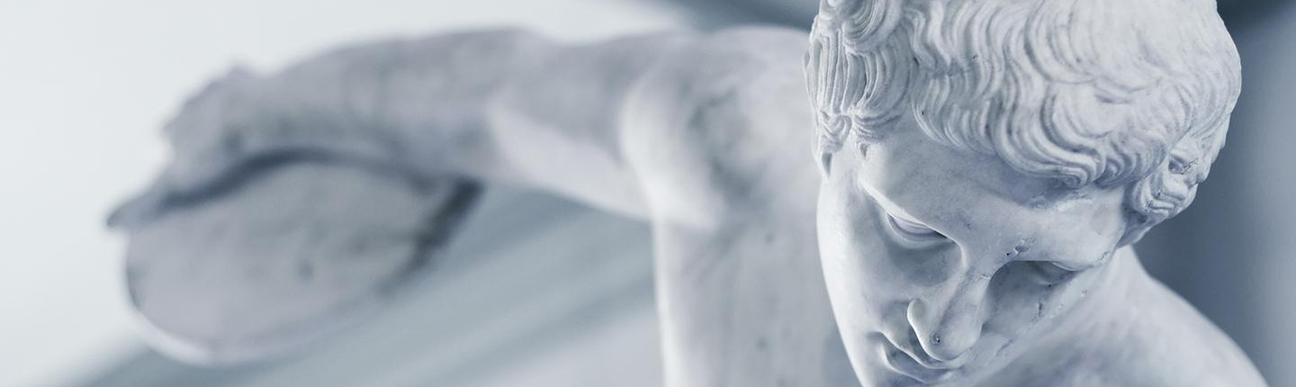 An ancient Greek or Roman sculpture of a man with his arm stretching back to throw a discus, representing the Classical Studies program at Occidental College (Oxy).