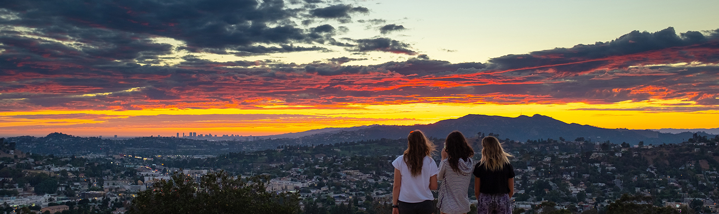 Students standing on Fiji Hill at sunset