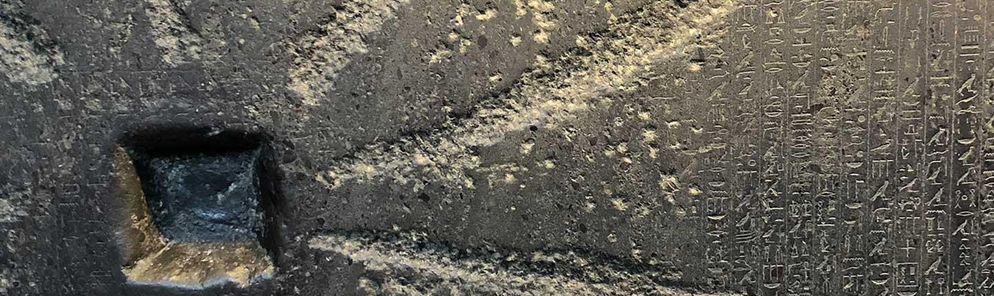 A close-up of an ancient slab of stone with carvings and heiroglyphics, representing the Comparative Studies in Literature and Culture department at Occidental College (Oxy).