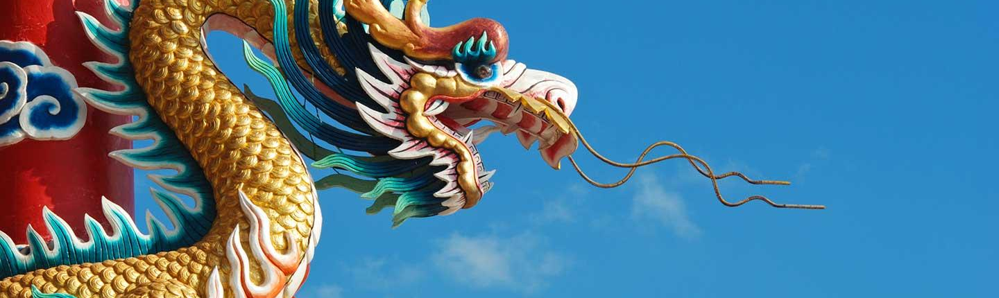 A traditional Chinese dragon sculpture against a blue sky, representing the Asian Studies department at Occidental College (Oxy).