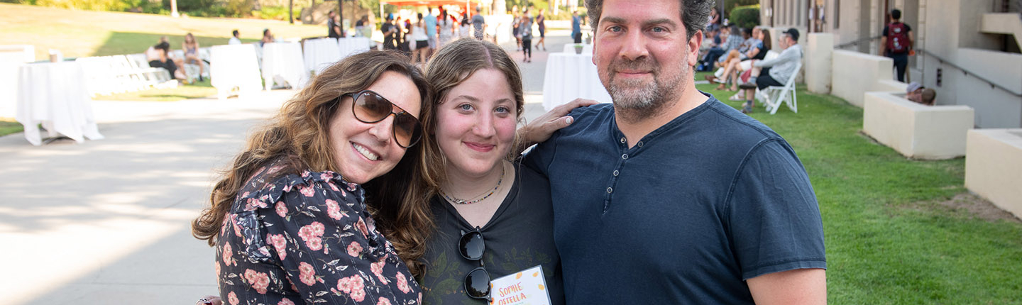A student embracing her parents