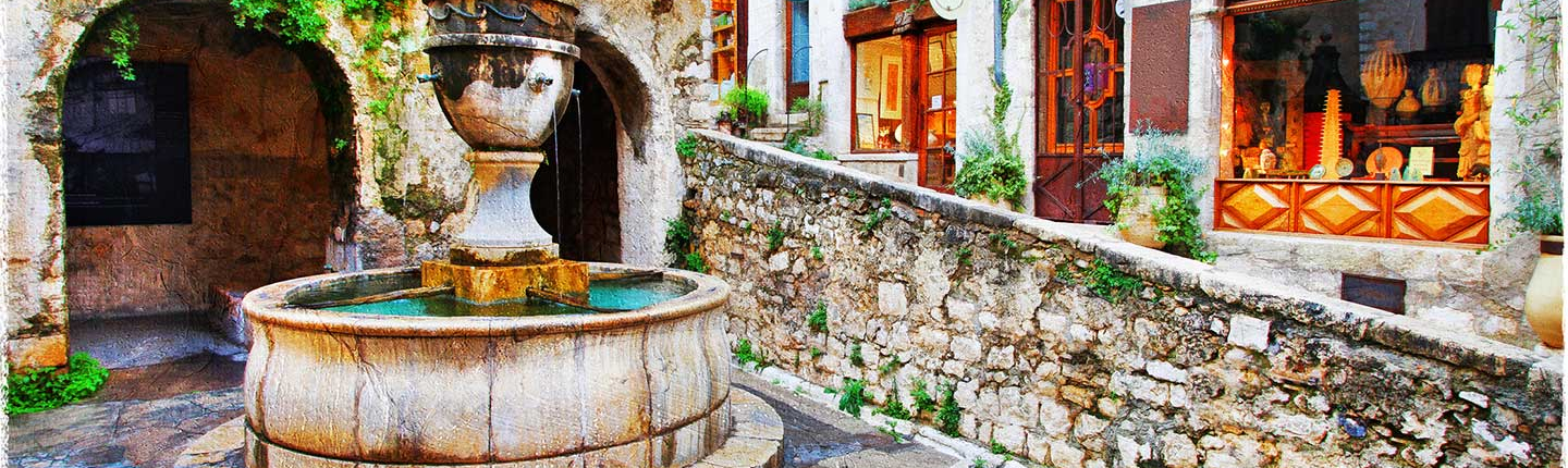 a picturesque street scene featuring the Place de la Grande Fontaine in the medieval hilltop village of Saint-Paul-de-Vence on the French Riviera. 