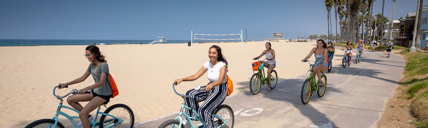 Students biking near the ocean in Venice