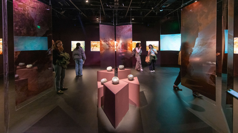 Inside an Oxy Arts exhibition gallery, with sculptures and hanging installments on either side.
