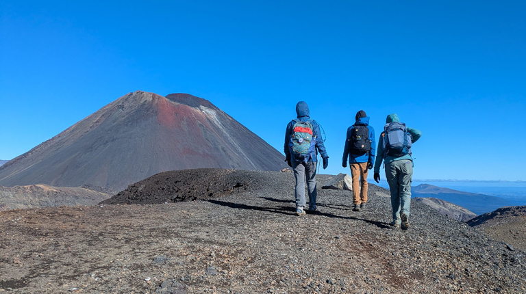 Occidental College students hiking with a large grey mountain in the background
