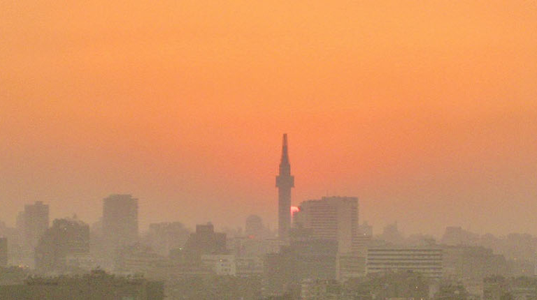 A sunset over the Cairo skyline, showcasing the city's iconic minarets