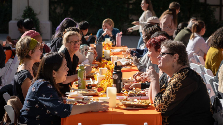 Occidental College staff members sitting together at a picnic table, talking