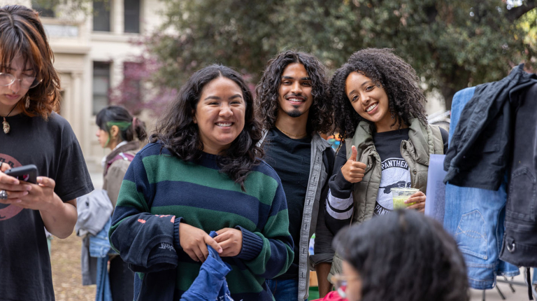 Three Occidental students standing together and smiling warmly