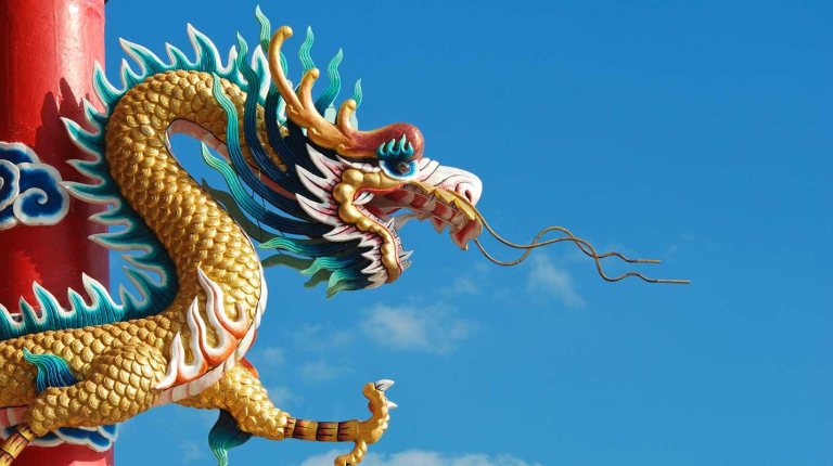 A traditional Chinese dragon sculpture against a blue sky, representing the Asian Studies department at Occidental College (Oxy).
