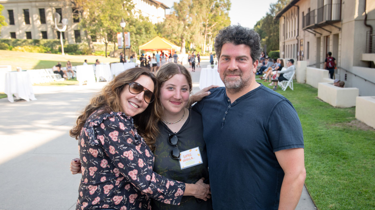 A student embracing her parents