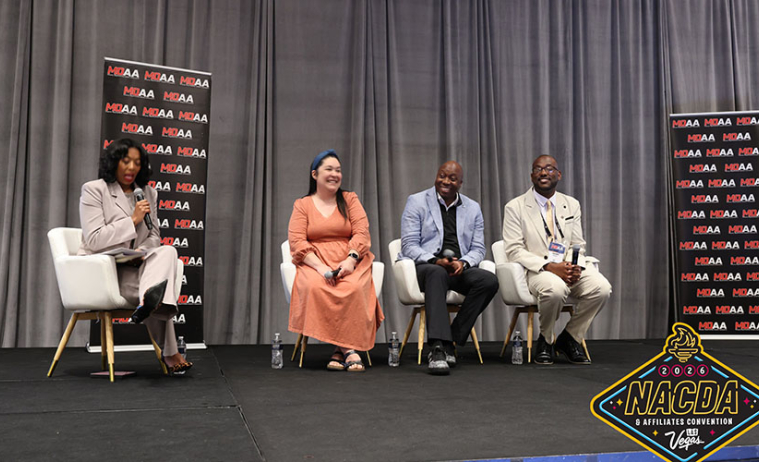 Awardees at the ceremony, four people seated on a stage