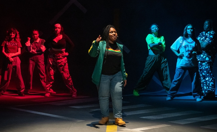 students in hip-hop clothing stand in a formation on the Keck Theater stage