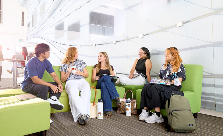Occidental students sit and talk near the media wall in Johnson Hall.