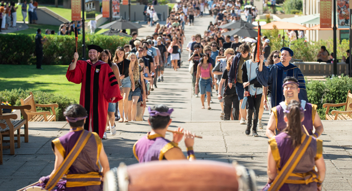 Two long lines of students walking up to Thorne Hall on campus for Convocation