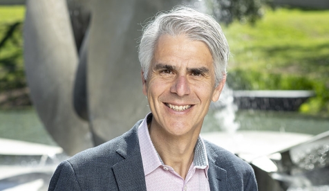 Occidental College President Tom Stritikus standing in front of Gilman Fountain