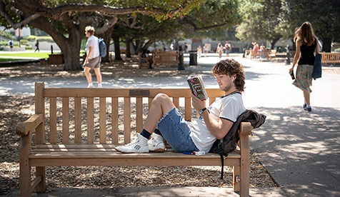 An Occidental student reads a book in the Academic Quad