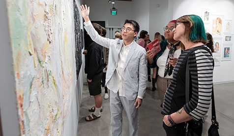 Occidental (Oxy) students gesturing and admiring a painting