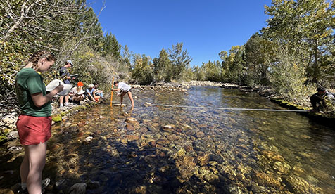 Occidental College students taking measurements by a stream