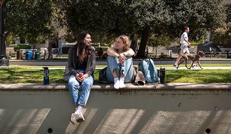 Two students at Occidental College - dog passing behind them