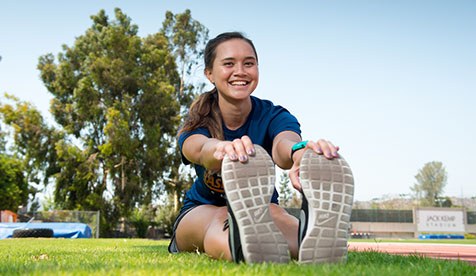 a person stretching outdoors on a field
