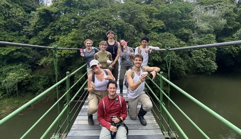 students on a suspension bridge in a jungle environment