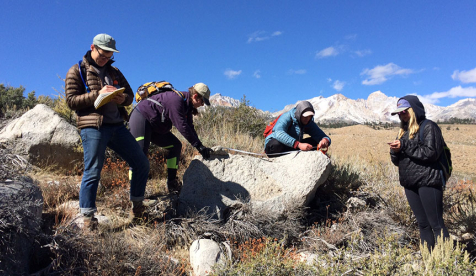 Occidental College students conducting geology research in the field with beautiful mountains in the background