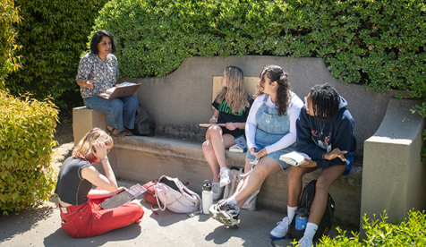 A professor takes her small class outside to learn in a courtyard