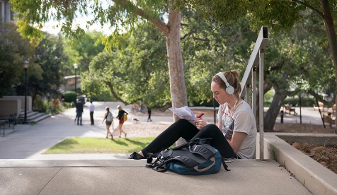 A student sits on the steps outside of the library on the Occidental campus in Los Angeles.