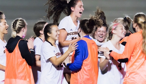 women's soccer players celebrate a win on the field