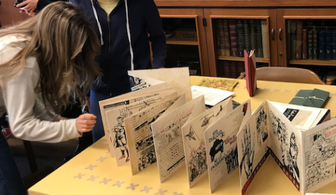 Students examine an old printed brochure from Oxy's special collection