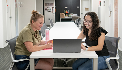 Occidental (Oxy) student and professor looking at a laptop together in conversation
