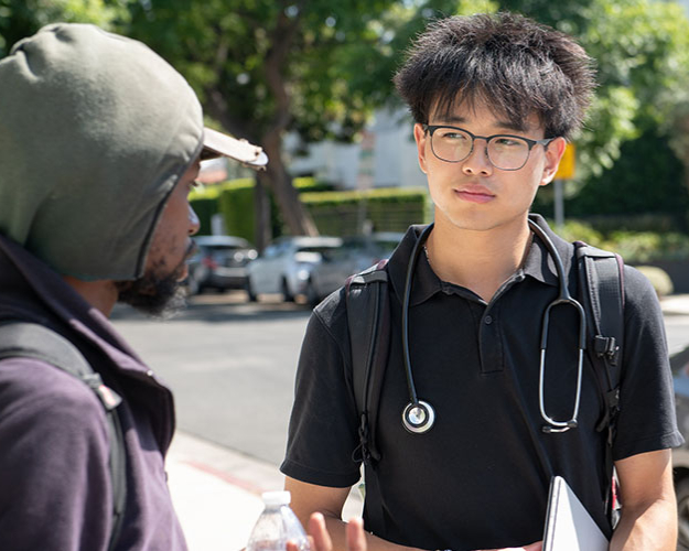 Occidental student Tylor Lee talks with an unhoused community member