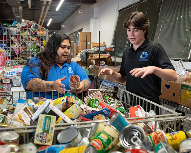 Occidental College student talking with a community partner at a local food bank