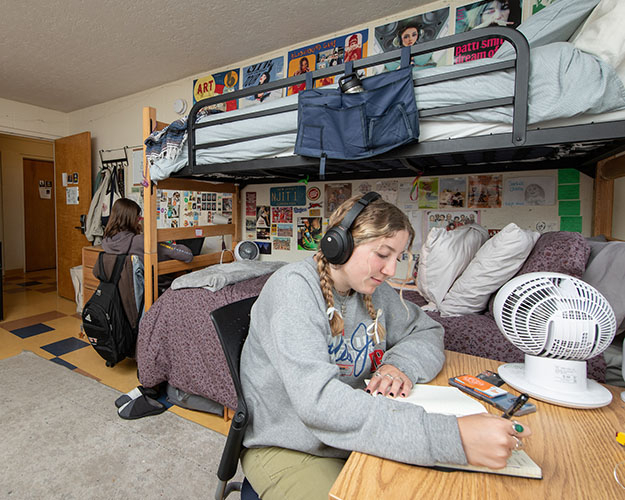 An Occidental student studying at her desk in her residence hall room