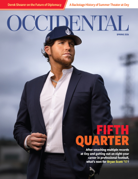 a man with a black suit jacket and black baseball hat on a sports field