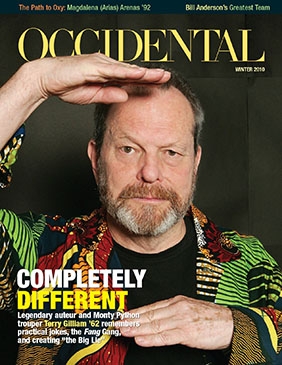 A man in a colorful shirt frames his face with his hands