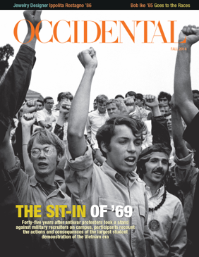 A black and white photo of a crowd with their fists raised. 